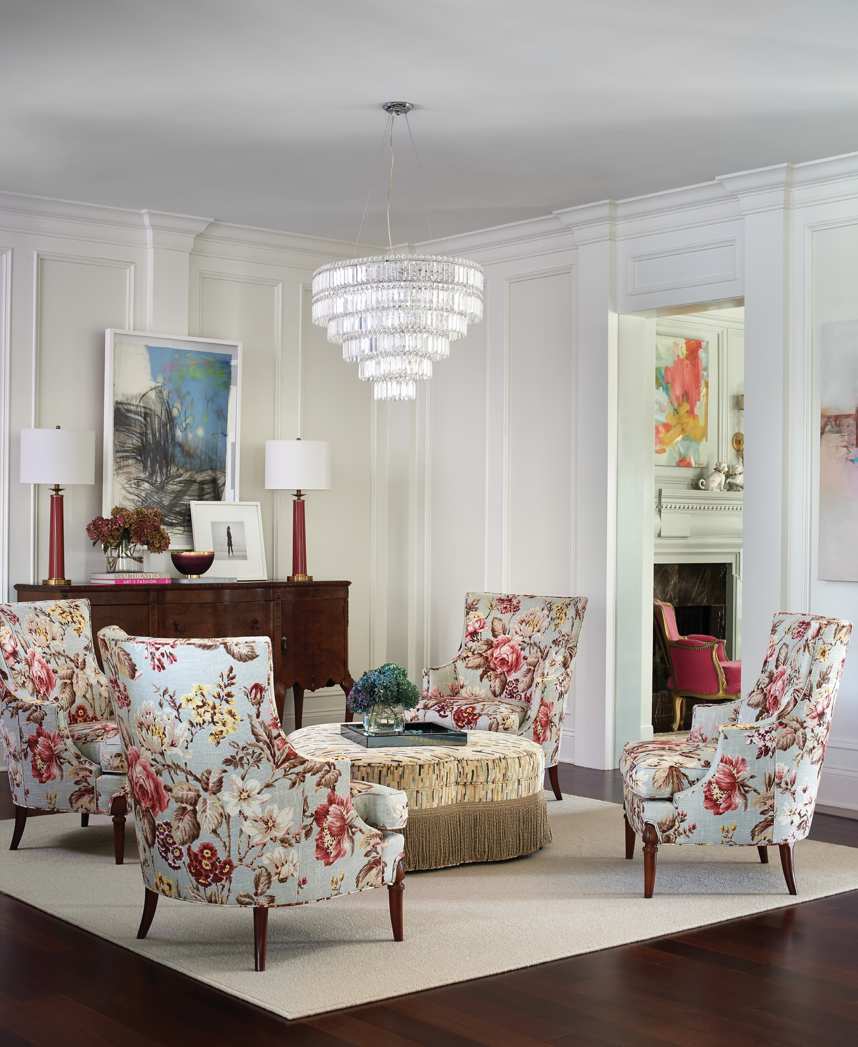 The feminine vibe from the neighboring library continues in the sitting room. A creamy area rug from Masland anchors the conversation space, with four Hickory Chair wingbacks and an ottomon covered in a Pearson fabric.