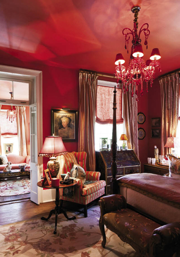 “Throughout the house, we wanted color that resonates happiness and daring,” says Juan. The second-floor guest suite in the main house is saturated in a fiery shade Juan deems “pimiento” before buoyantly adding, “and the chandeliers are bordello red.” Visitors to this “Scarlet O’Hara Room” are afforded their own sitting area and a piazza that presents a sweeping view of the garden.