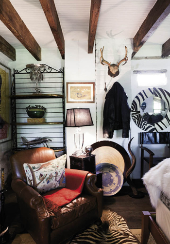 The “Safari Room” features earth-toned fabrics, rugged furnishings, and African art, as well as game trophies, a zebra-skin rug, and an alligator-skin motorcycle jacket hung on the wall.