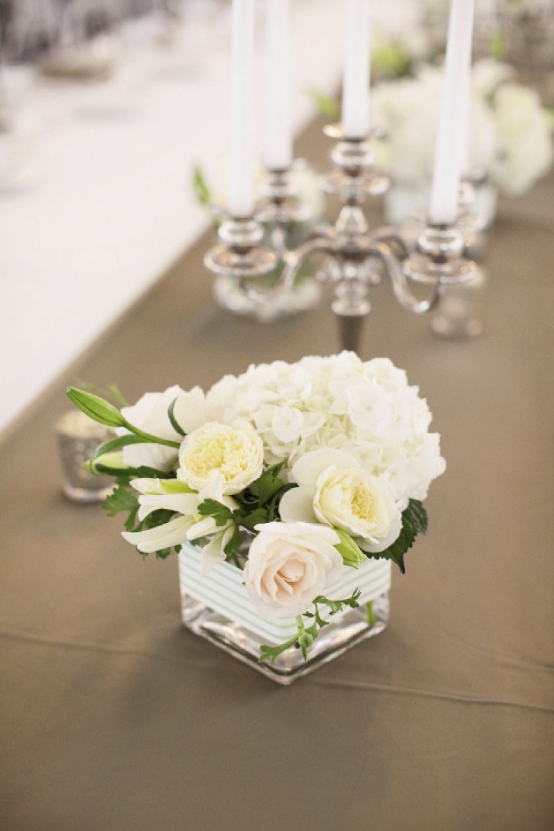 EARN THOSE STRIPES: The stripes on the couple’s stationery suite also accented vessels with blooms from Jade Water Designs.