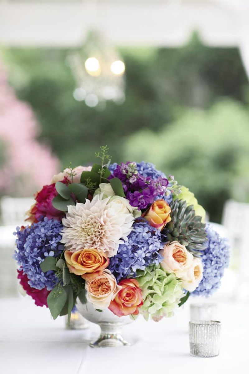 MIX IT UP: To add depth to the color palette of blue, green, and ivory, Anne Bowen of stems added succulents, eucalyptus, and peach roses to the tabletop arrangements.