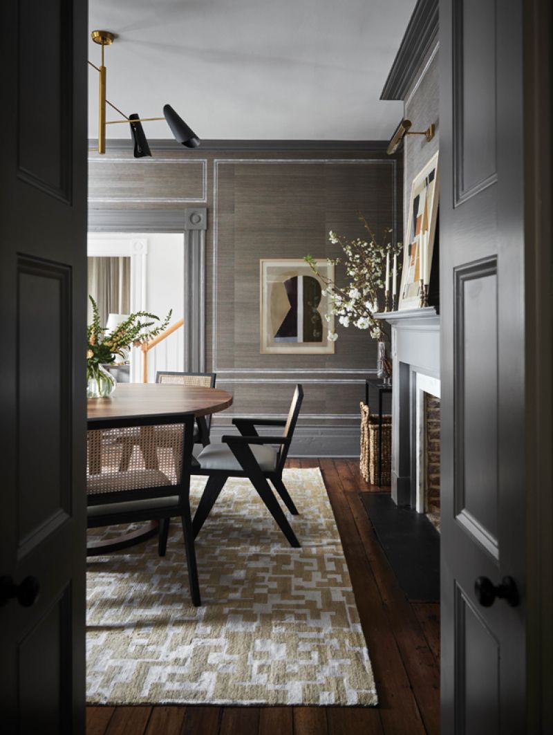 Across the hall, the dining room is more moody, ensconced in Phillip Jeffries “Juicy Jute” grass-cloth wallpaper in “Natural Slate.” Berry had decorative painter Jessica Kollar of Jess Artistic Designs apply the effect of “paneling” to the walls, evoking an architectural element that elevates the room.