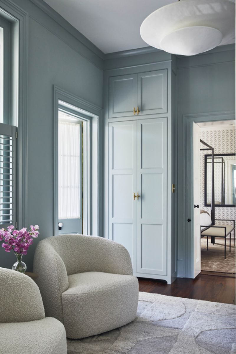 In the adjoining sitting room painted in Benjamin Moore “French Toile,” two ivory boucle chairs from CB2 flank an Arteriors drink table, providing a calming space for the homeowners to relax.