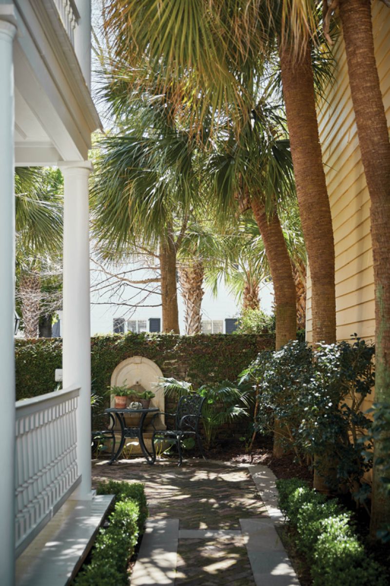 Secret Garden: While the house is set back from the street courtesy of a large front yard with  manicured boxwoods, this secluded terrace, tucked behind the home’s double piazzas, features lush palms and a fountain, providing  a serene, private oasis.