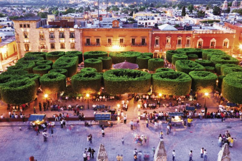 A view of the city’s bustling central square, El Jardín, at dusk