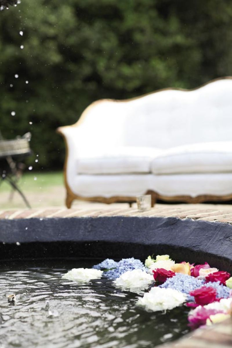 SWIMMING LESSONS: Lizz Ackerman of Southern Protocol floated pale  blue, peach, white, and fuchsia blooms in a fountain on the grounds.