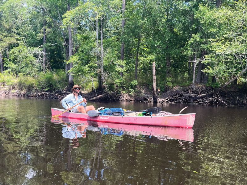 The author settles into river time in his fully loaded canoe.