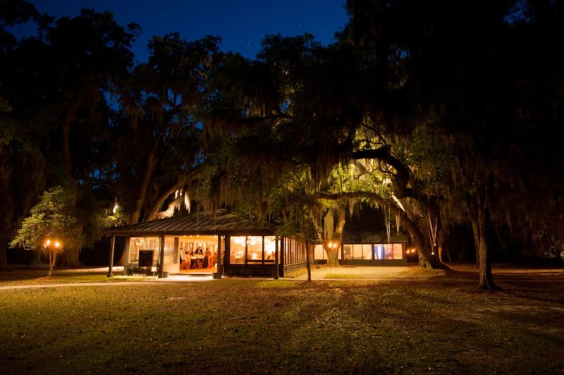 SCENIC GLOW: Technical Event Company’s lighting softened the indoor space for a cozy feel during the twilight hours. “Patrick and I were so pleased with how the reception glowed from the candlelight and string lighting,” says D’Anne. “The light sparkled off the chandelier and glassware.”
