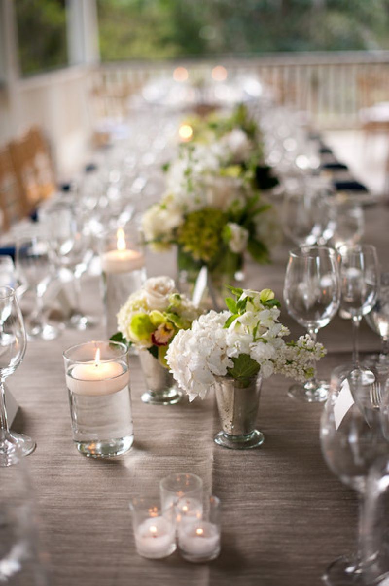 A LOVELY LANDSCAPE: Clear and mercury glass vessels held simple arrangements and candles at varying heights.