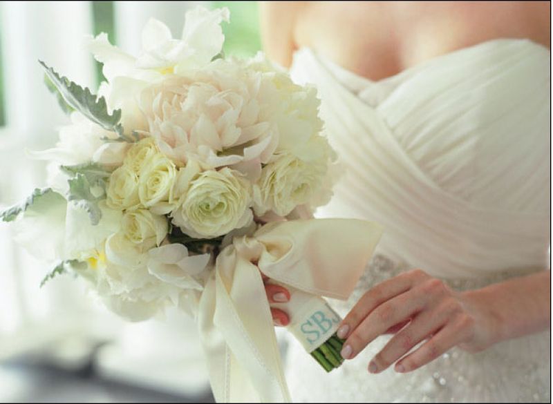 A SOFT TOUCH: Tara Guérard Soirée combined spray roses, light pink peonies, Dusty Miller, and orchids for Sara’s textured, elegant bunch. The bride’s stitched initials lent a subtle something blue to her look.