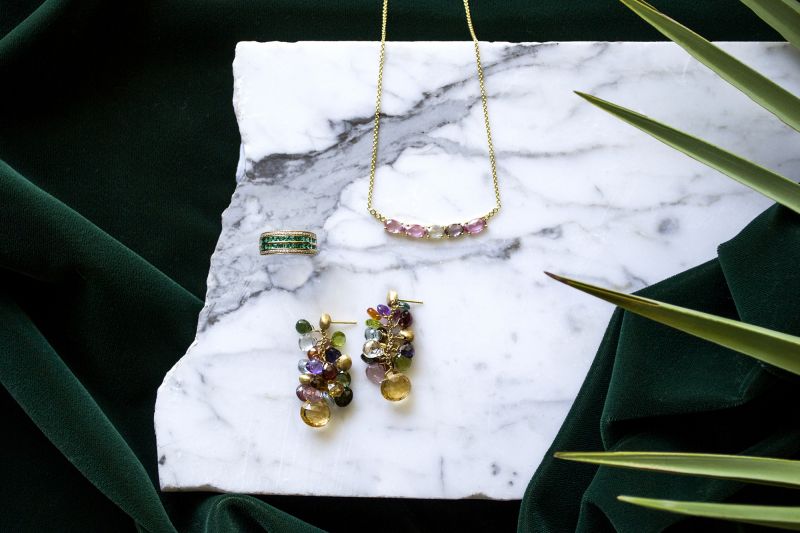 (Clockwise from top right) 18K yellow-gold 5.0 ct. multi-sapphire and .05 ct. diamond necklace, $3,450 at Croghan&#039;s Jewel Box; Marco Bicego 18K yellow-gold multicolor earrings, $6,625 at Sandler’s Diamonds &amp; Time; ring no longer available