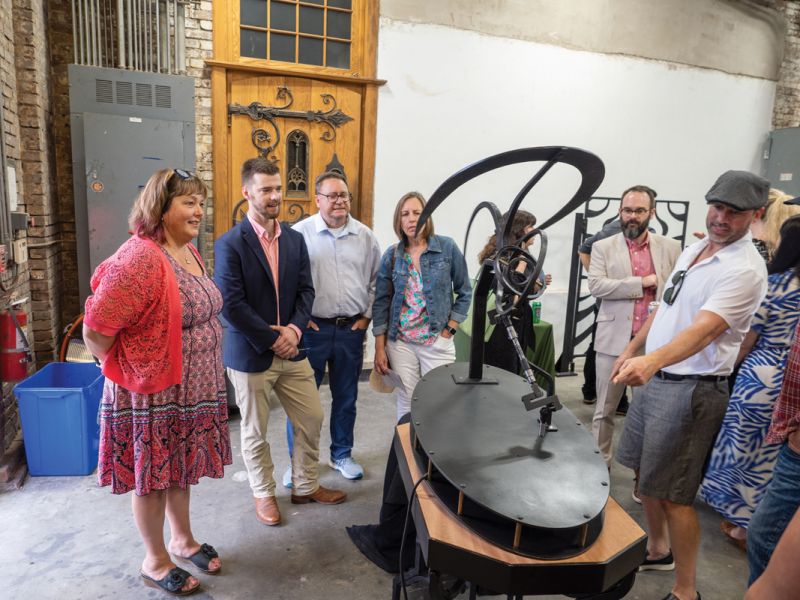 Will Hankinson (second from left) shows his forged and fabricated kinetic sculpture.