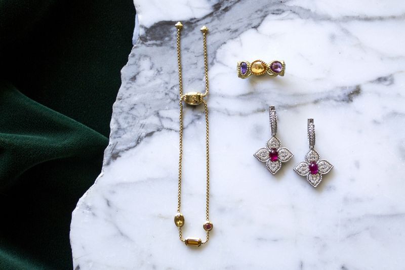 (Clockwise from top right) 18K gold and 6.36 ct. multi-sapphire eternity band, $3,100 at Croghan’s Jewel Box; David Yurman 18K Novella chain bracelet, $1,350 at REEDS Jewelers; 18K white-gold diamond “Ruby Princess” flower earrings, $8,500 at Roberto Coin; David Yurman 18K gold Novella chain bracelet, $1,350 at REEDS Jewelers