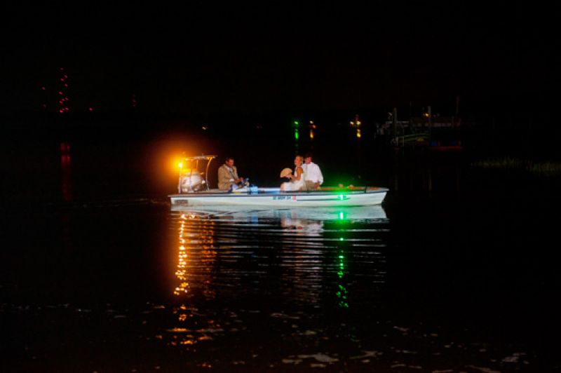 ALL ABOARD! The newlyweds waved goodbye to family and friends as they exited via the creek that runs along Boone Hall Plantation.