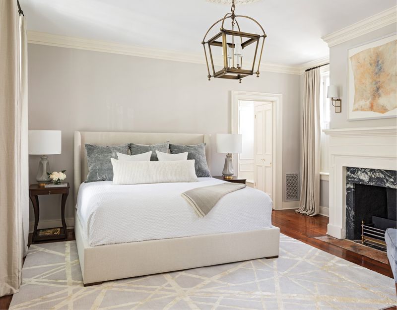 Anchored by Art: The art collection dictated the interior design, including the three light-filled bedrooms. A Rick Horton piece in the primary bedroom evokes the rich tones of the heart-of-pine flooring and antique brass Urban Electric chandelier.