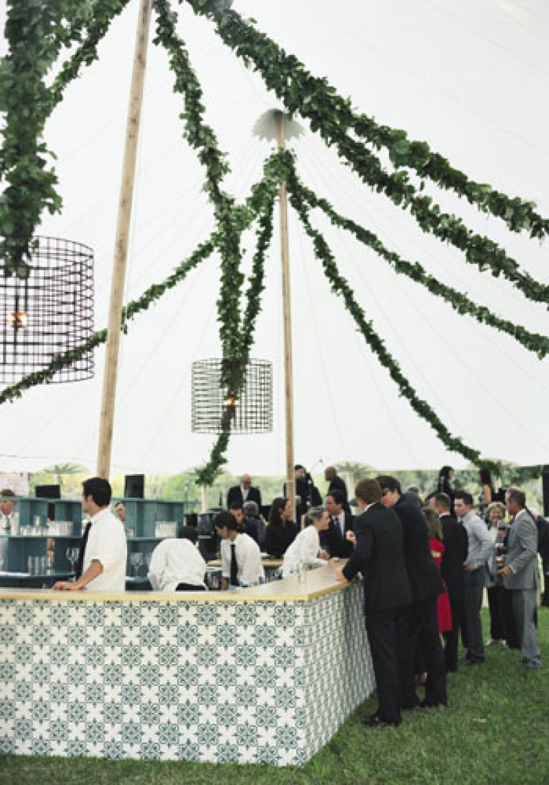 Raise the Bar: Raise the Bar: Drum pendant lights, swags of greens, and fabric dressed up the bar.