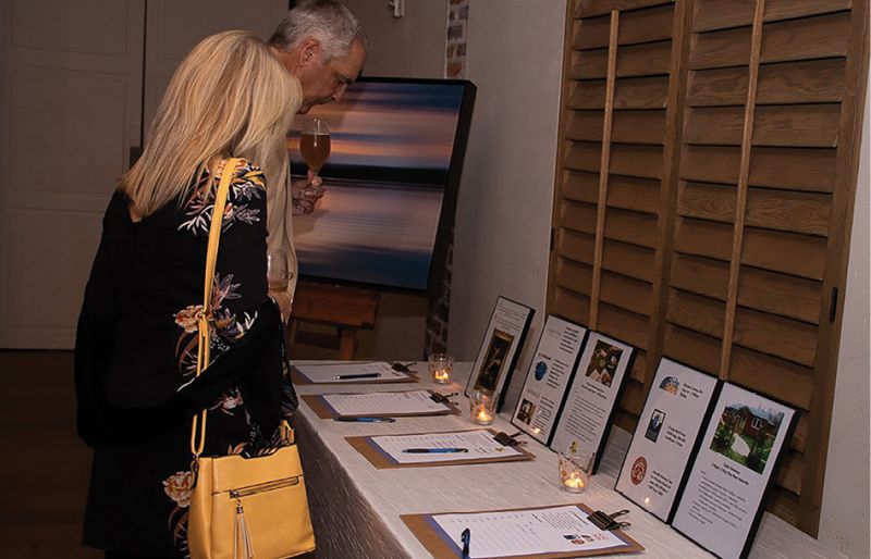 Guests bid on items in the silent auction, including tickets to local events, certificates to fine dining restaurants, and handmade goods and artwork.