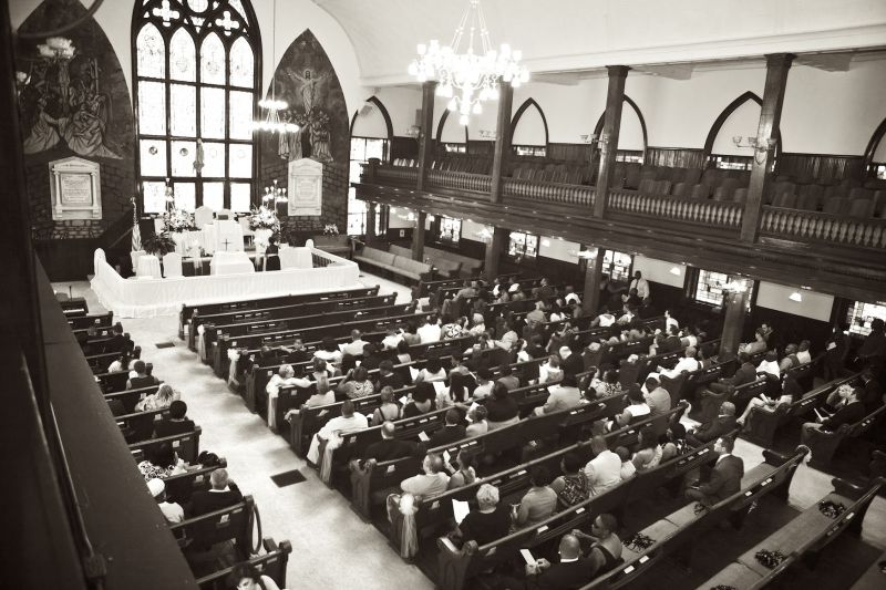 ALL DRESSED UP: The altar was draped with white linens, dressing up the church’s dark, wooden interior. In addition, Panther blue pom poms—a nod toward the couple’s cheerleading and football personalities—were placed in the pews for guests to wave as the couple exited.