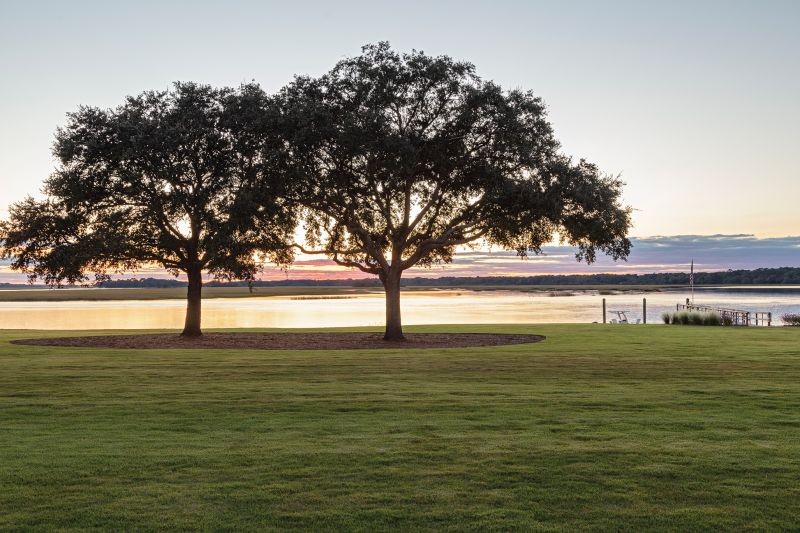 The property faces southwest over Bohicket Creek, affording spectacular sunsets framed by majestic oaks.