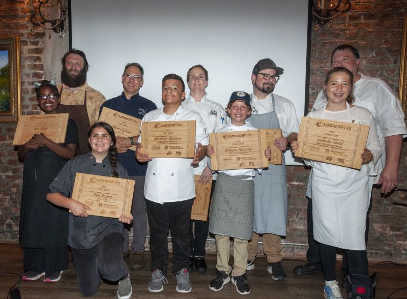 Bob Cook, Marc Collins, Robyn Guisto, Will Fincher, Richard Plaistowe, Nia Khan, Ella Bruno, Abraham Aguilera, William Herring, and Isabella Hurd display their cutting boards from Louie for a job well done.