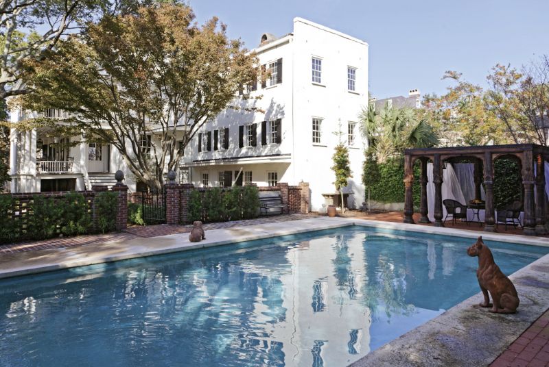 UNCOMMON GROUNDS A carved teak pergola stands at the far end of the pool, which is located in what once was the property’s stableyard.