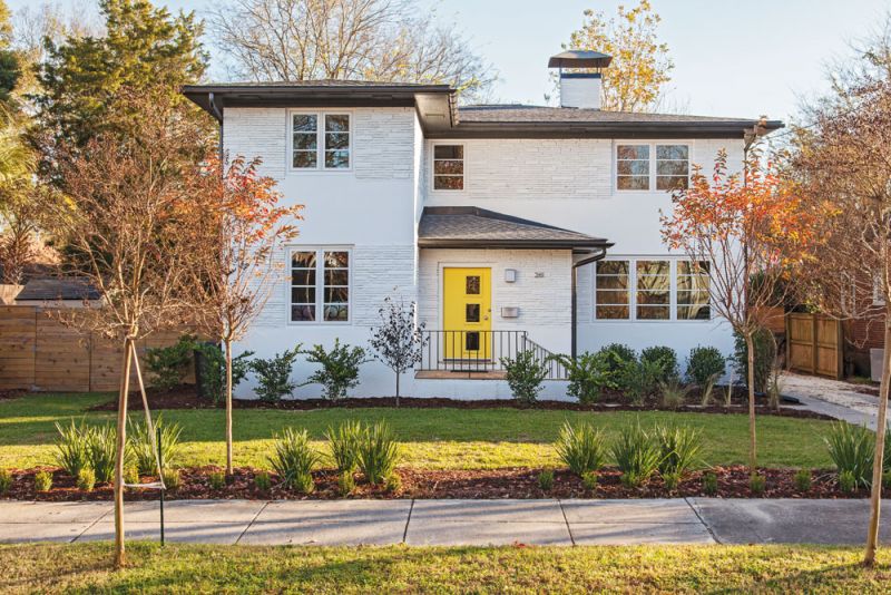 HELLO, SUNSHINE: Thanks to a whitewashed exterior and bright yellow front door, the simulated stone-and-stucco façade really pops.