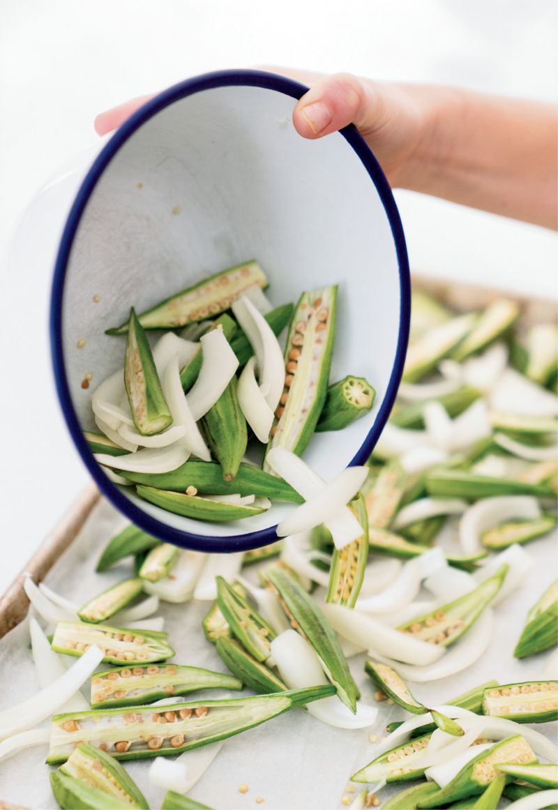 For the roasted okra, onions are added to the halved pods. After roasting in the oven, the dish is spiced up with cumin, chili powder, and cilantro.