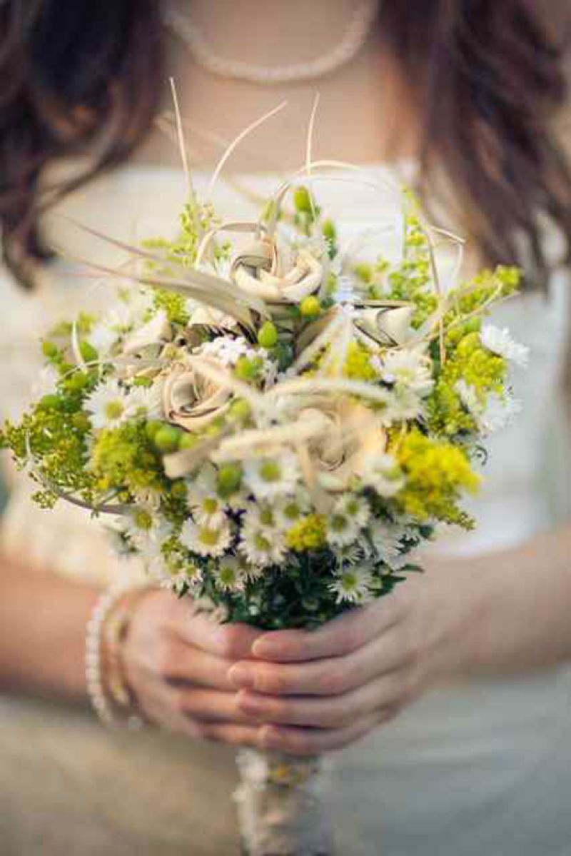 NO ORDINARY GROUP: Catherine told Debi Brickell of First Bloom of Charleston that she wanted a bouquet that looked like wild flowers—a vision the florist realized by combining a sea of Monte Casinos with palmetto roses (the same ones, in fact, that Zack gave to Catherine the day he proposed). The bunch was held in place by lace from Catherine’s mother’s own wedding gown.