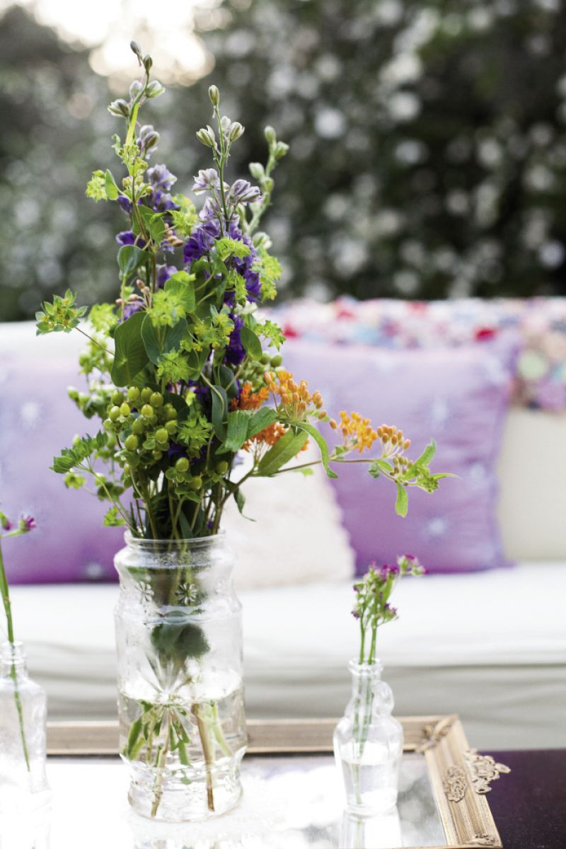 BOTTLED UP: “I wanted each arrangement to be unique, colorful, and have a loose, wildflower look,” says Catherine, who relied on First Bloom of Charleston to make it so.