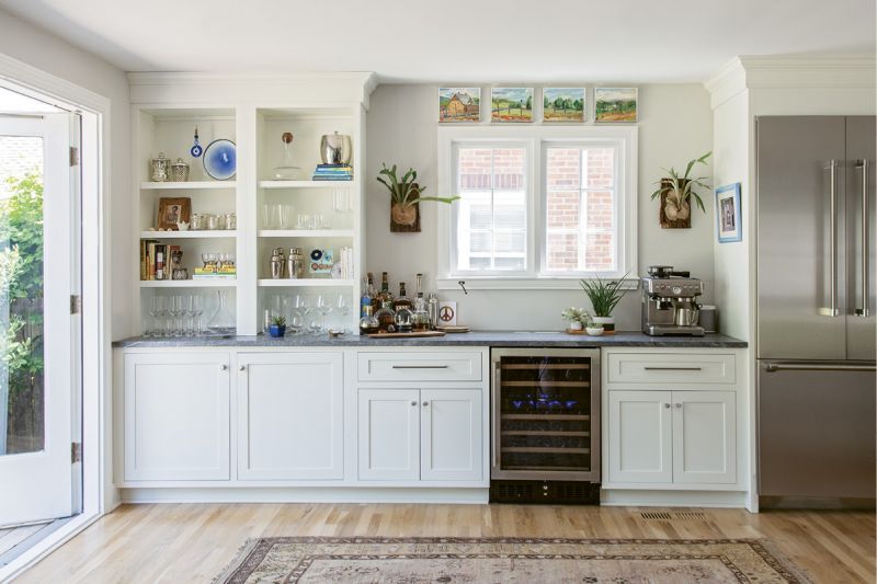 The kitchen flows into an open, airy entertaining space, which Rachel left free of furniture to allow for yoga sessions and late-night dance parties. There, antler-like staghorn ferns from Hyams Garden Center flank the window.