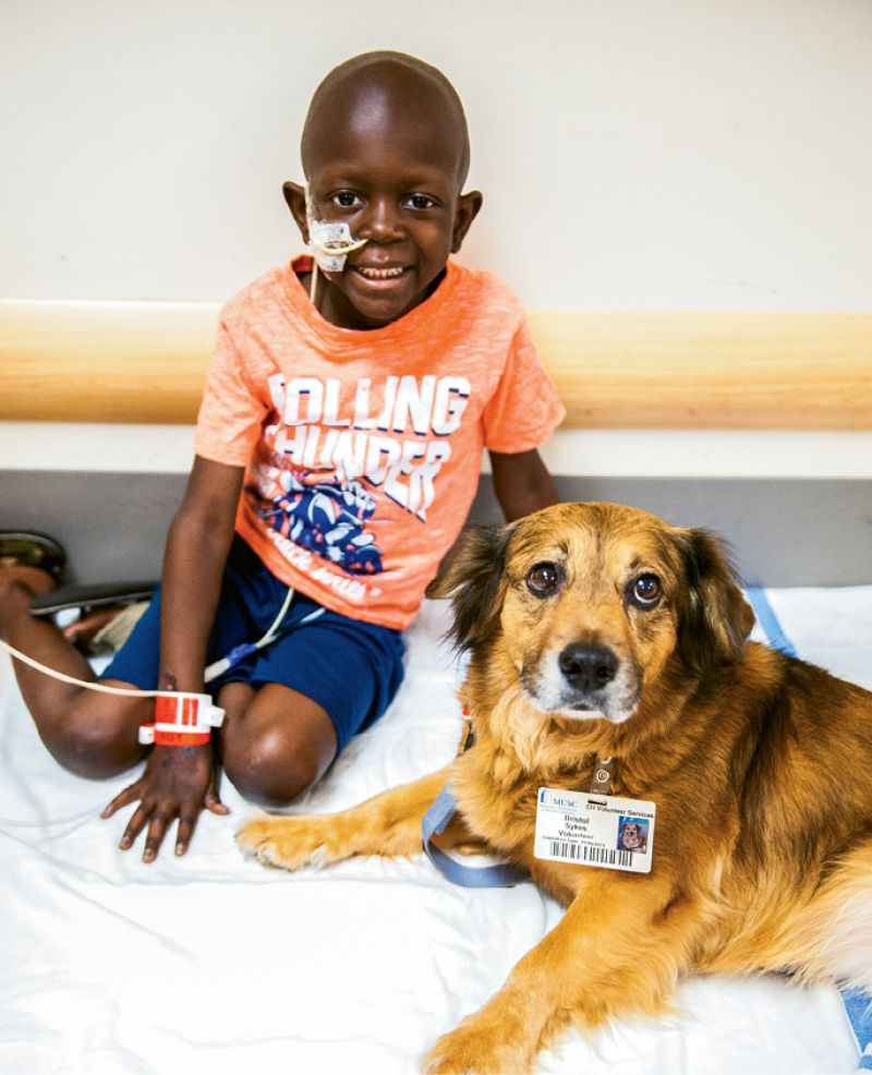 Bristol visiting with a patient, Trenton, at MUSC