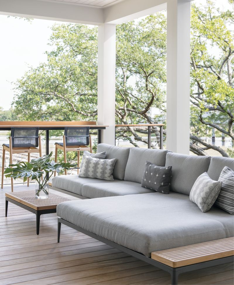 Modern Mood: The Grid sectional and chairs from Gloster mix modern and organic, steel and teak, all accented by neutral greys and whites in the outdoor living room. “The back of the house is literally a nature wonderland,” says Lenox. “I felt the dichotomy of incorporating very modern furniture into such a natural landscape was interesting and unexpected.”