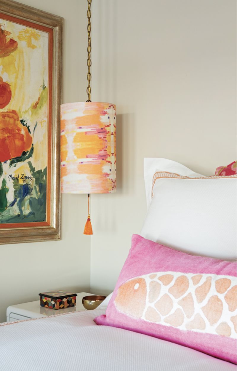 The third bedroom boasts a pendant drum shade covered in a pastel pink and orange Cindy Barganier fabric, which plays with the large, velvet fish pillow from Elizabeth Stuart.