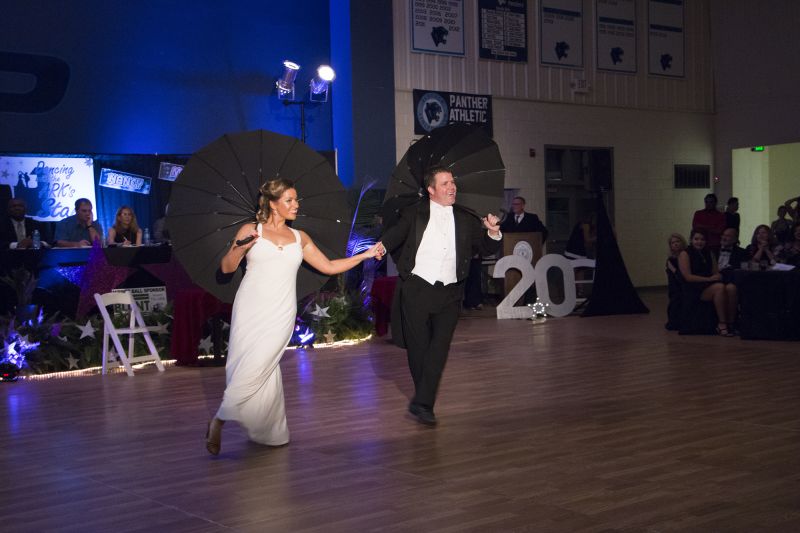 Marina Fridmanovich and Matt Orosz adorably stroll under black umbrellas.