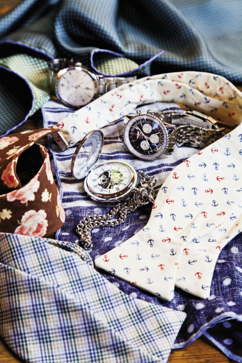 TIMEKEEPER: (clockwise from top) Robert Talbott’s green and cream polka-dotted pocket square from Gwynn’s of Mt. Pleasant. Swiss Army’s stainless steel wristwatch from Skatell’s. Barry Beaux’s anchor bow tie from Charleston Tuxedo. Breitling’s Navitimer 01 stainless steel watch from Kiawah Fine Jewelry. Ermenegildo Zegna’s polka- dotted and striped pocket square from Gwynn’s of Mt. Pleasant.  Skeleton’s flip-top pocket watch from Skatell’s. Brinko Ties’ bow ties from Rogue Wave Surf Shop.