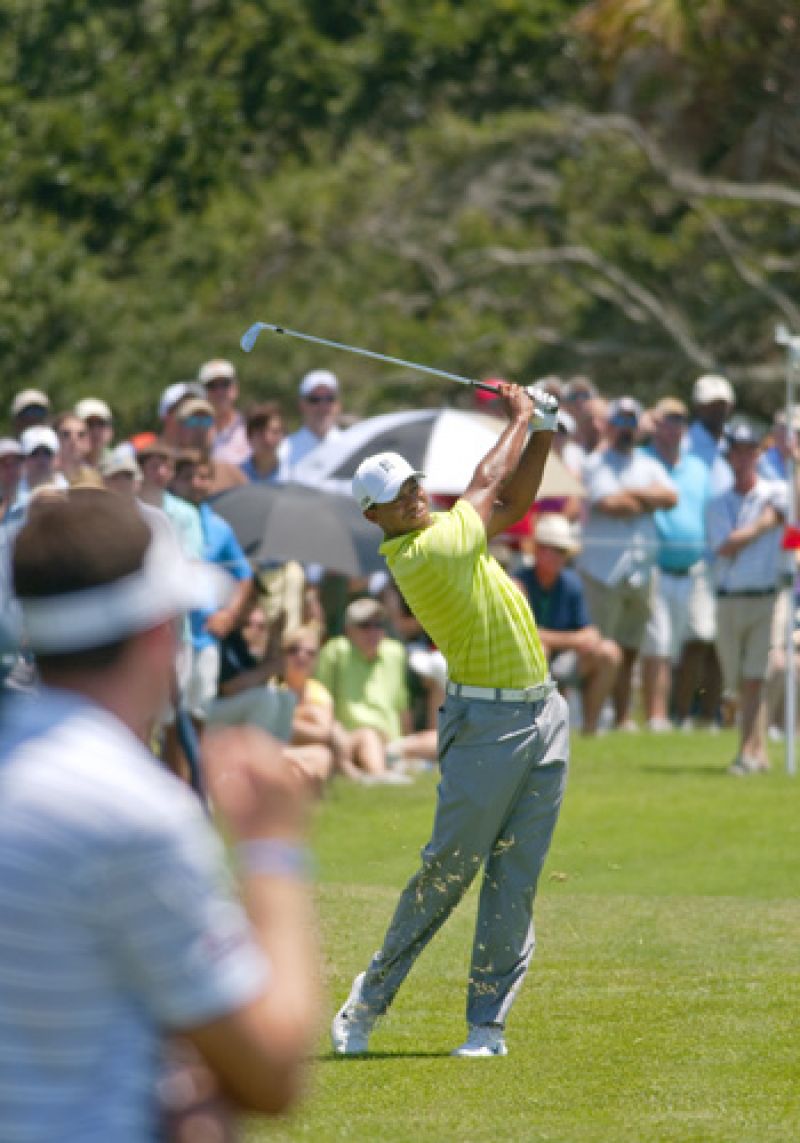 Tiger hits his aproach shot on number 9 while Keegan Bradley watches.