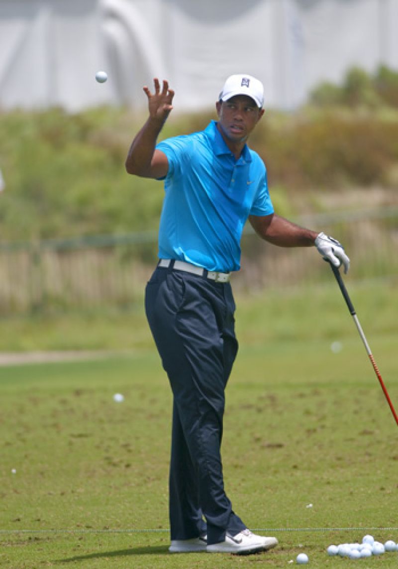 Tiger grabbing a ball from his caddie in his pre-round warm up.