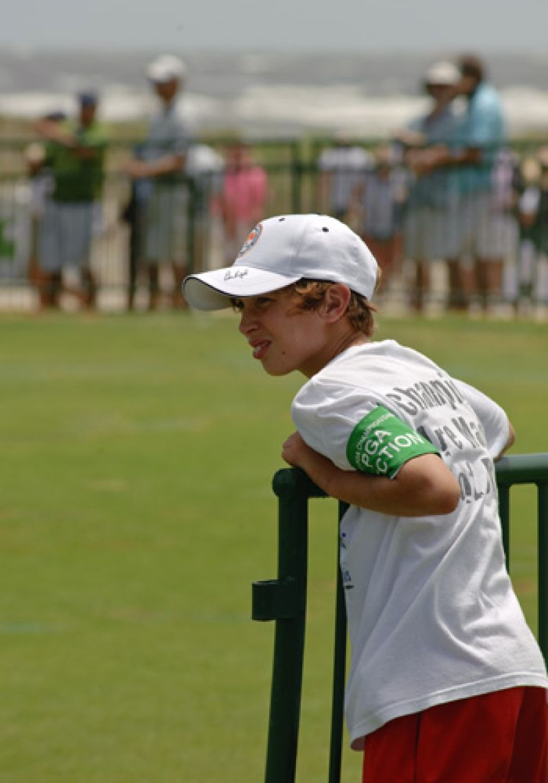 A young fan with a behind the ropes arm band.