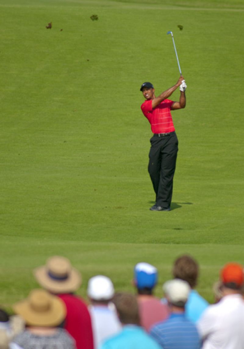 Tiger kicking up a huge divot out of the 18th fairway.