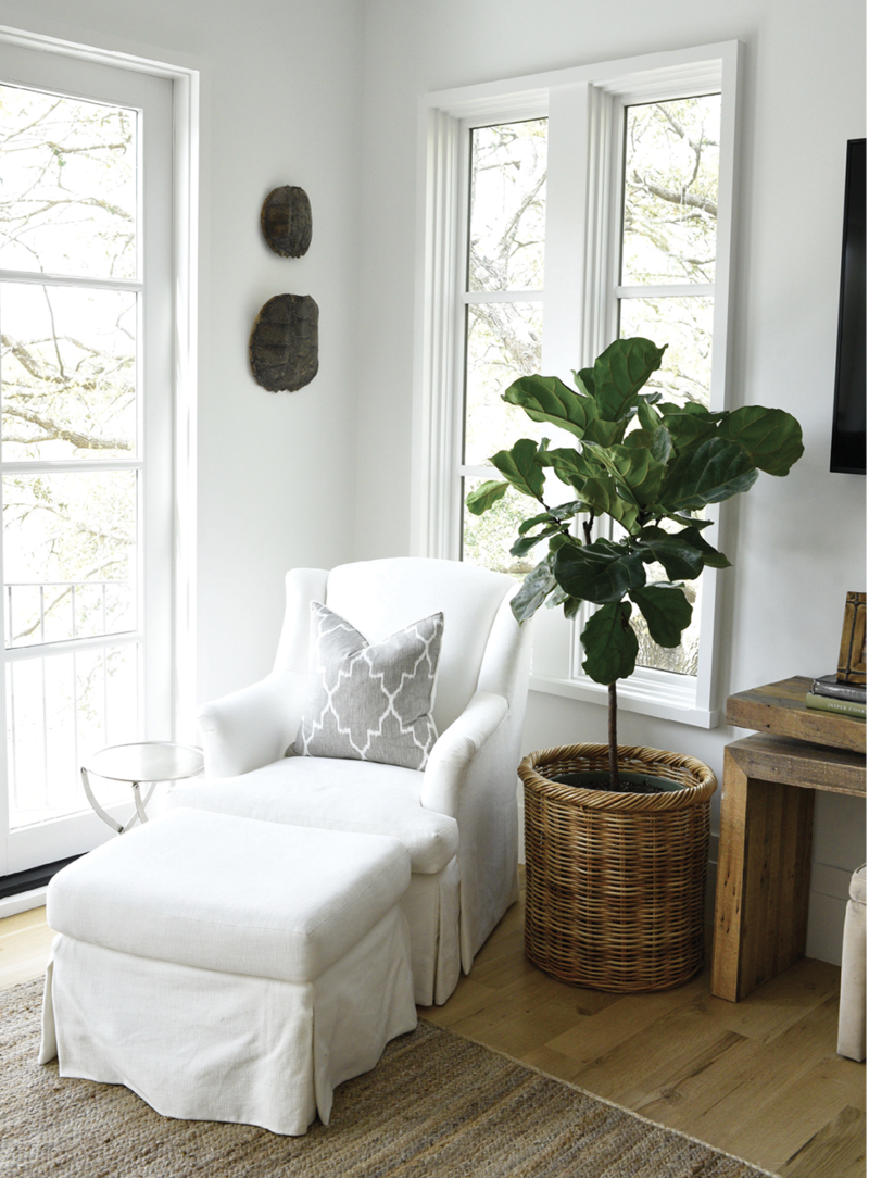 The white chair and ottoman from Acquisitions Interiors makes for a cozy reading nook in the bedroom.