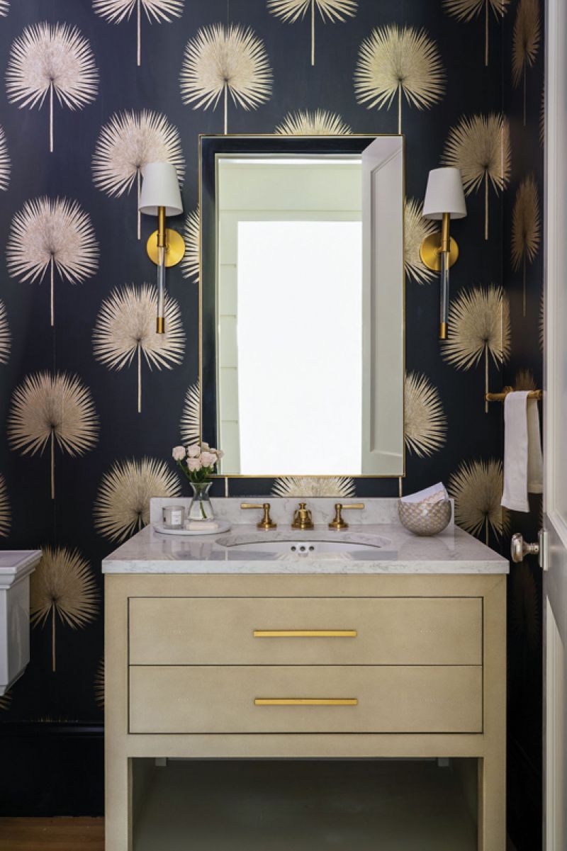 The bold “Fan Palm” wallpaper by Sanderson in the powder room complements a creamy Restoration Hardware vanity and brass wall sconces by Visual Comfort.