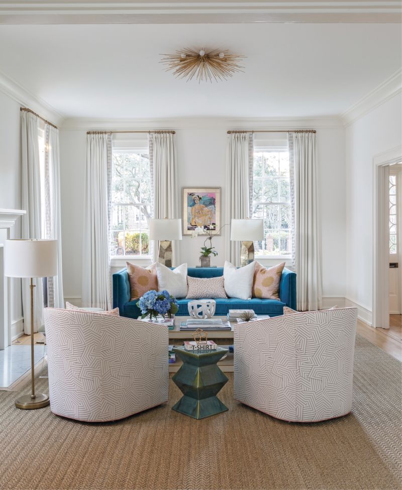 SITTING PRETTY: Cate’s art collection set the palettes for the interiors, including this striking figurative work by Anne Darby Parker overlooking a vibrant blue Jonathan Adler velvet sofa and pale blush of the Schumacher fabric-covered club chairs.