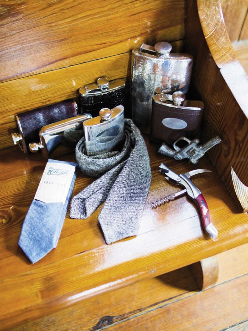 SECRET STASH: (clockwise from top right) Vintage hammered sterling silver flask and brown leather flask with monogram keyhole, both from Croghan’s Jewel Box. Pistol-shaped bottle opener from Out of Hand. Wooden inlay wine bottle opener from M. Dumas and Sons. The Hill-side ties from Indigo and Cotton. Pewter flask with monogram medallion and silver flask with ball knob topper, both from Croghan’s Jewel Box. Cowhide-covered and crocodile-covered flasks, both from Out of Hand.