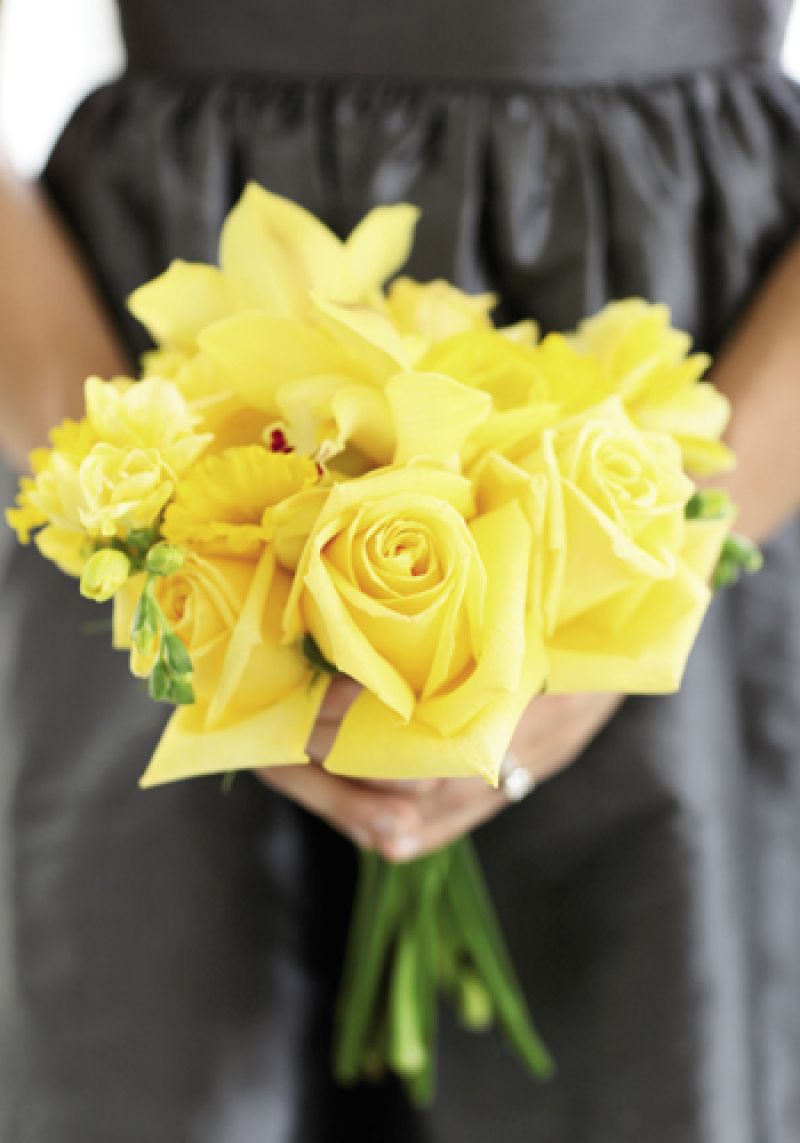 GOLD RUSH: Stems fashioned bouquets of yellow daffodils, freesia, orchids, and roses, made all the more vivid by the bridesmaids’ charcoal-colored LulaKate dresses.