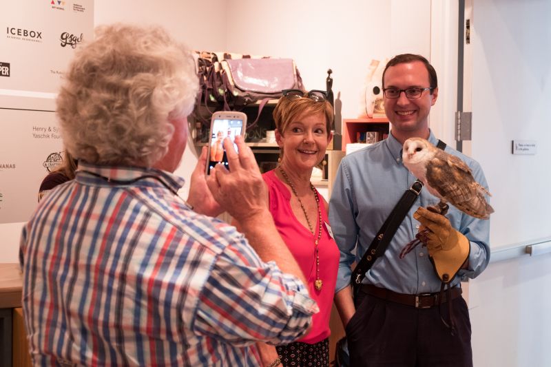 Gerri Greenwood poses with the owl while her husband, Linn Greenwood, snaps a photo.