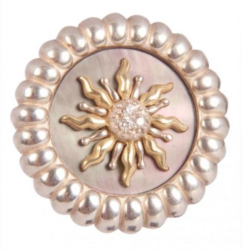 Slane 18K yellow gold and sterling silver sun centered with approximately .042 TCW diamonds against a black mother of pearl backdrop, $1,060 at Reeds Jewelers; photograph by Sophia Parker