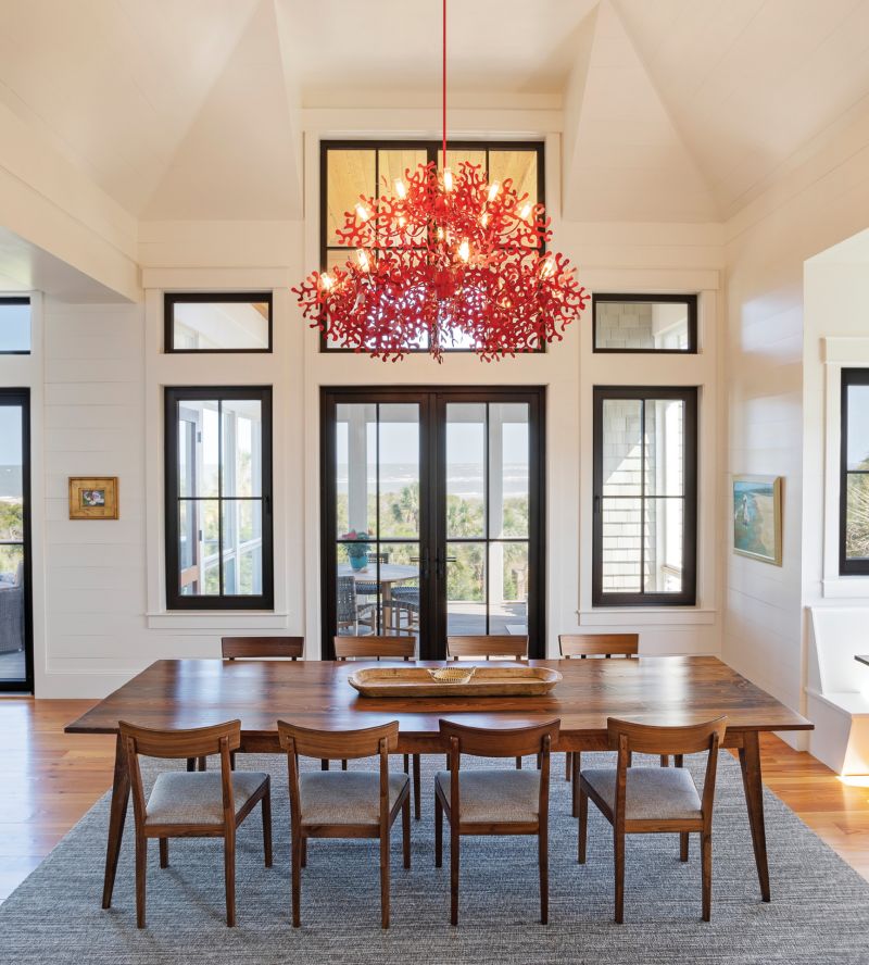 Of Earth &amp; Sea: A striking red “coral” chandelier by Villa Tosca Design in Italy hangs above a handcrafted dining table by Landrum Tables of North Charleston. The juxtaposition is the centerpiece of the Beischel family house on Dewees Island, designed by architect Myles Trudell to be a multigenerational home that’s comfortable, casually elegant, and infused with a sense of whimsy.