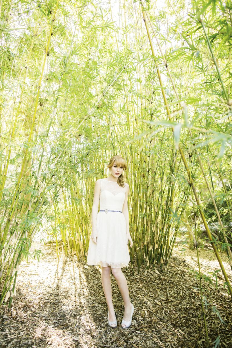 OFF THE BEATEN PATH: Theia’s Chantilly lace and organza dress from Gown Boutique of Charleston. Blue ribbon belt with star detail from Onawa Designs. 14K white gold, pearl, and  diamond earrings from Croghan’s Jewel Box. Lava Shoes’ “Mylie”  silver glitter peep- toe pumps from Jean’s Bridal.