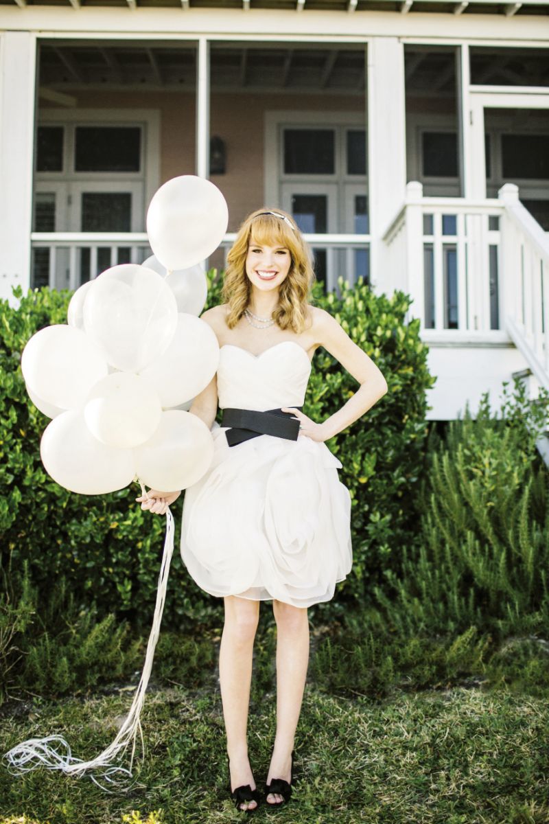 FLOAT AWAY:  Wtoo’s strapless dress with organza swirled skirt and crisscross belt and Elle &amp; Jae’s Grecian style headband with crystal brooches, both from Bella Bridesmaid. SLANE’s milky aquamarine necklace from REEDS Jewelers. 18K white gold, emerald, and diamond ring from Croghan’s Jewel Box. kate spade new york’s “Clarice” peep-toe pumps from Copper Penny Shooz. Balloons from Party Plan-It; helium from Hughes Party Rental.