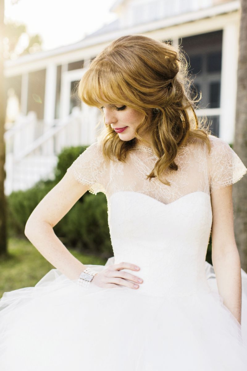 RIGHT ANGLE: Marchesa’s  “Theodora” lace bodice and layered tulle ball gown from White on Daniel Island. Matthew Campbell Laurenza’s sterling silver, quartz, and rhodium earrings from Paulo Geiss Jewelers. Cultured pearl bracelet from Croghan’s Jewel Box.